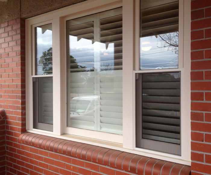 flyscreens on lower windows of brick home